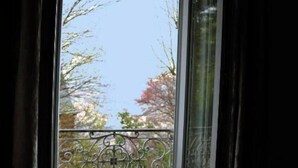 A room with a window overlooking a balcony with a wrought iron railing. - Maison Valmer - L'armateur, Élégant Penthouse Classé 4 Étoiles (Le Havre)