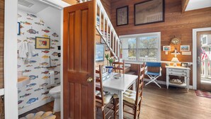 Un interior de madera con comedor, una escalera y vistas al exterior.