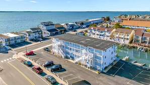 Ein Hotel an der Küste mit mehreren Etagen, einem Parkplatz und Blick auf das Meer.