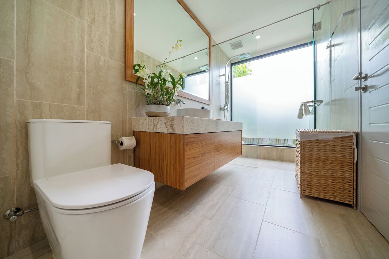 Une salle de bain moderne comprenant des toilettes, un meuble-lavabo et un espace douche.