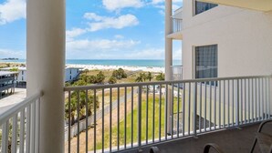 A balcony with a view of a beach and ocean.