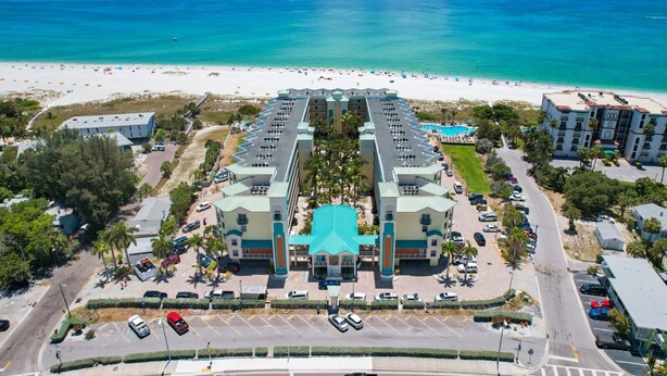 A hotel with a central courtyard, multiple floors, and a beach view.
