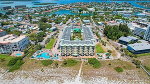 An aerial view of a resort with a central building surrounded by a pool area and multiple buildings.