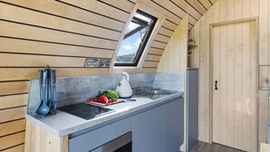 A compact kitchen with wooden paneling, a built-in stove, and a window above the sink. - The West Front, Cathedral View - Hot Tub - Pets - Free Parking & WiFi (Wells)