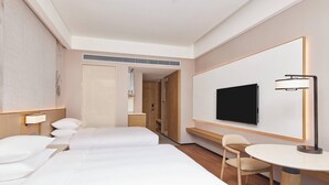 A hotel room with two beds, a TV mounted on the wall, a desk with a chair, and a lamp. - Courtyard By Marriott Jiuzhaigou (Ngawa Autonomous Prefecture)