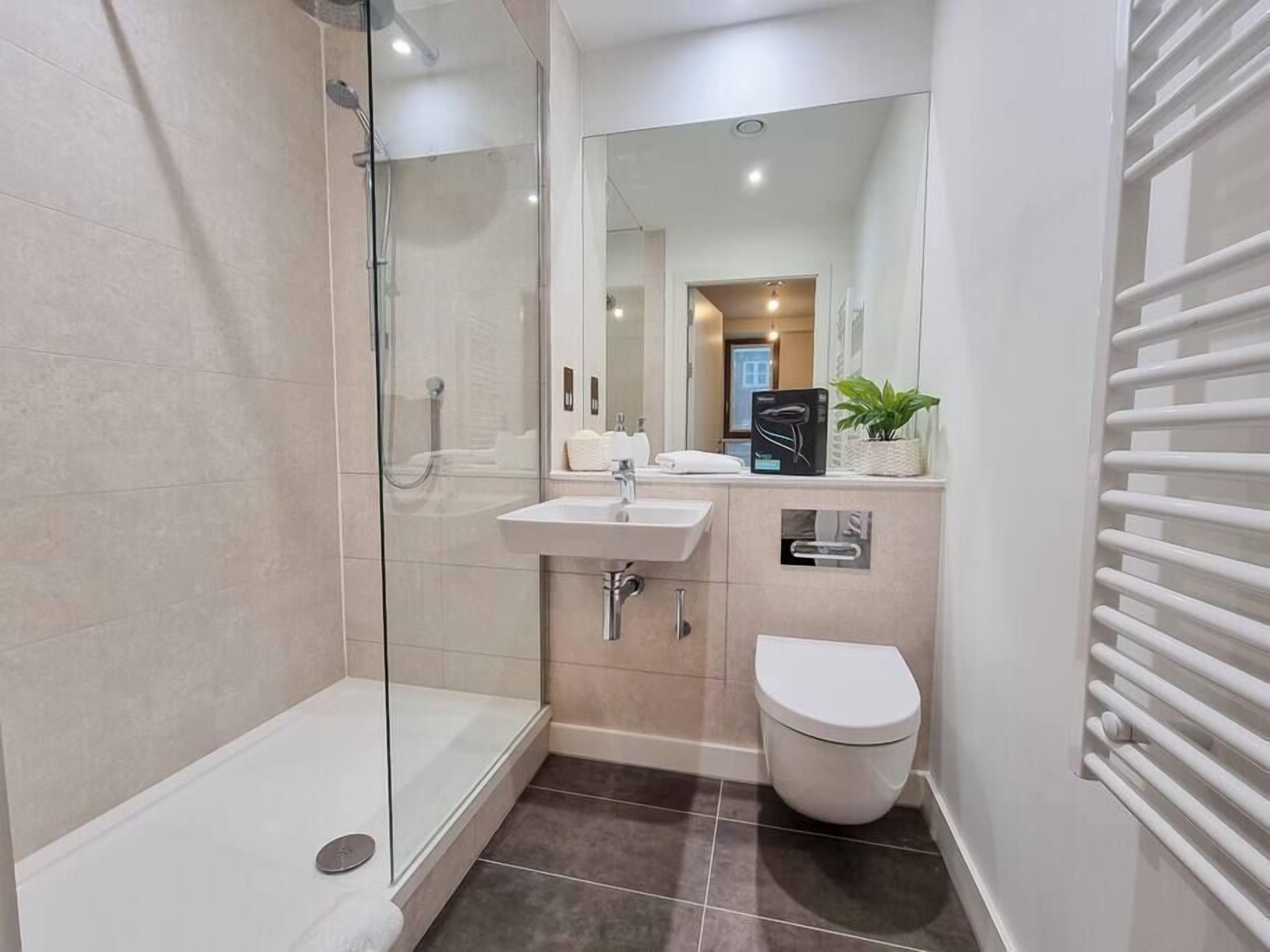 Bathtub, hair dryer, towels, shampoo