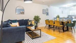 Ein Wohnzimmer mit einer Couch, einem Couchtisch und einem Essbereich mit Stühlen und einem Tisch.