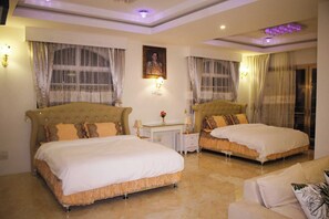 A hotel room with two beds, a desk, and a sofa. - Narong Ek Residence View & Pool Villa (Patong)
