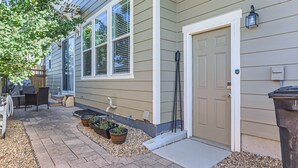 A house with a front porch, outdoor seating, and potted plants.