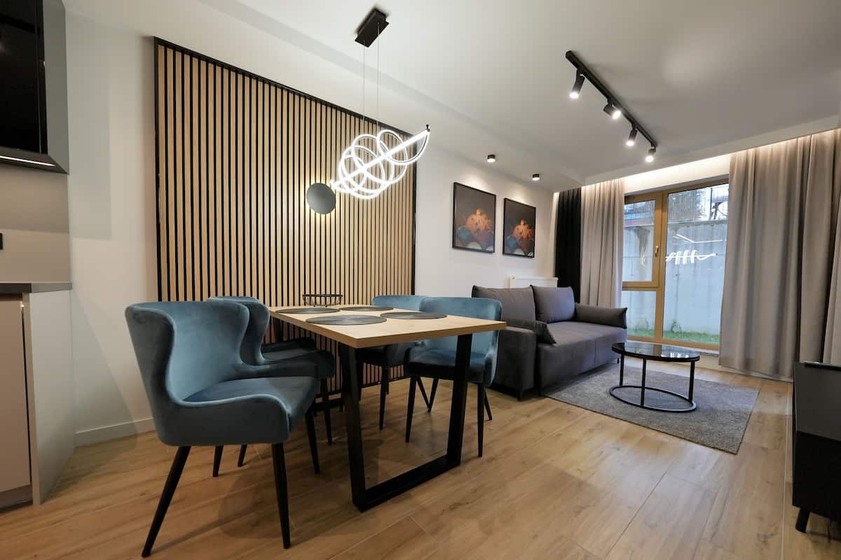 Una sala de estar moderna con comedor, un sofá y un televisor.