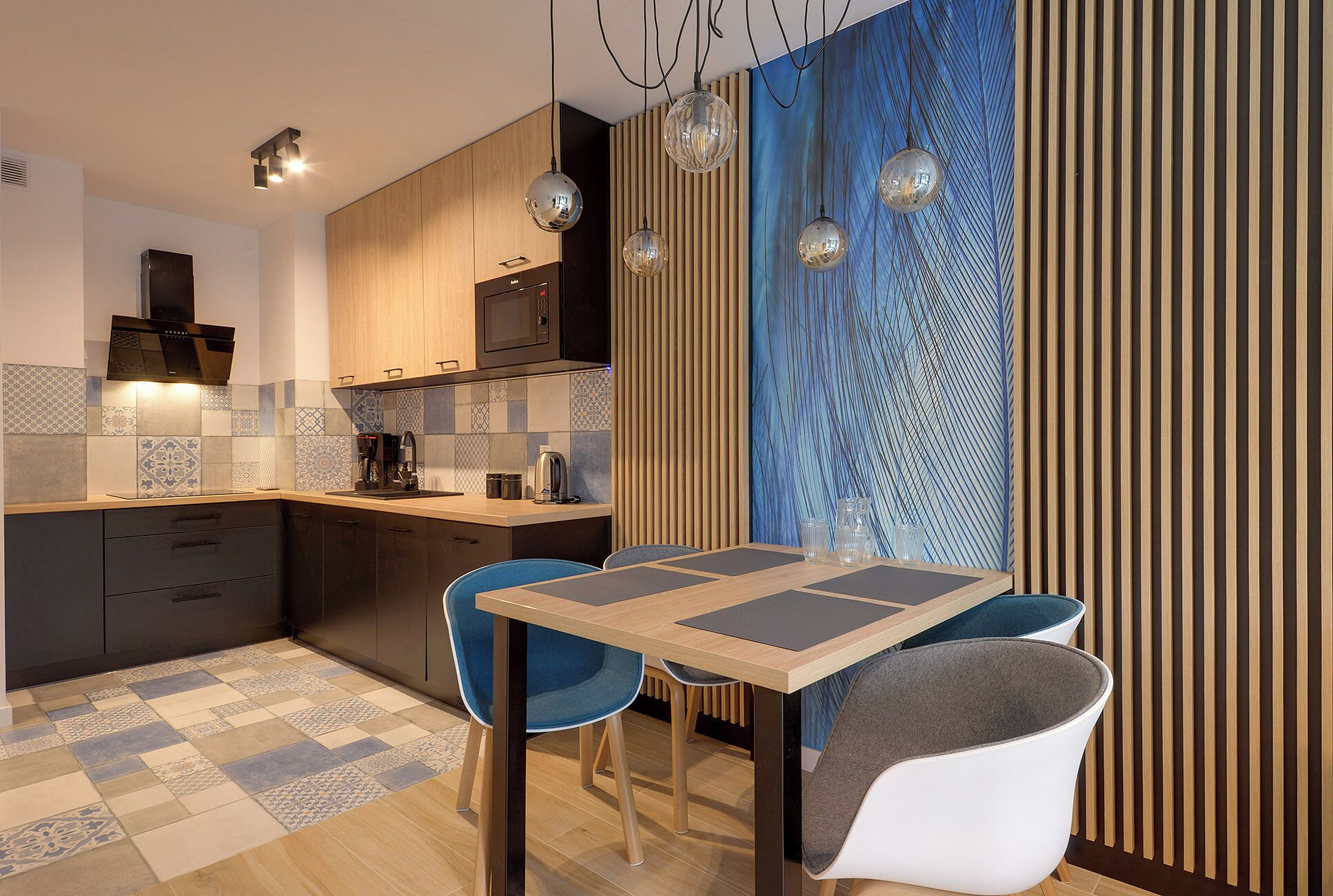 A modern kitchen with a dining area, featuring a wooden cabinet, a microwave, and a coffee maker.
