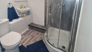 A modern bathroom with a glass-enclosed shower, a white toilet, and a sink with a mirror above it. - Beautiful 1-bed Apartment in North London (London)
