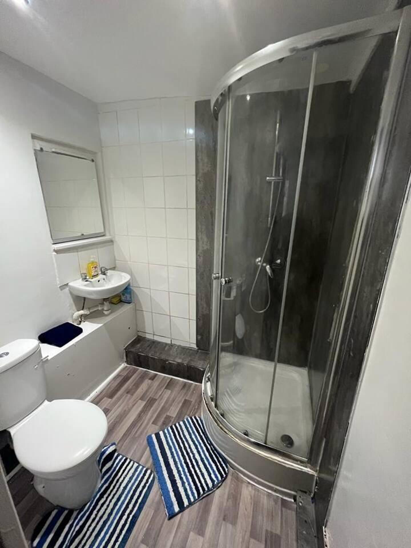 Un baño con inodoro, lavamanos y ducha.
