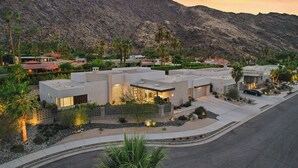 A modern residential area with contemporary houses, landscaped gardens, and a mountain backdrop. - Cosmopolitan - Walk to Palm Canyon! (Palm Springs)