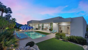 A modern house with a swimming pool, outdoor seating, and a well-maintained garden. - Cosmopolitan - Walk to Palm Canyon! (Palm Springs)