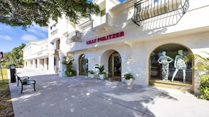 A building with a storefront named 'Lily Pulitzer' featuring mannequins in the window.