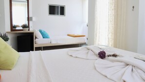 Habitació d'hotel amb llit, tauleta de nit, mirall i finestra amb cortines.