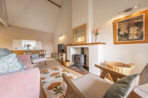 A cozy living room with a fireplace, comfortable seating, and a dining area.