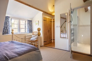 Relax in a spacious bedroom with a large bed, a comfortable seating area, and a stylish wardrobe with a mirror.