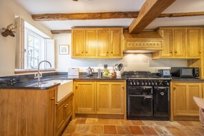 Kitchen features a large window, mounted deer head, and modern appliances.