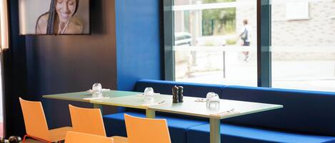 A modern dining area with a table, chairs, and a blue bench.