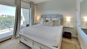 Un dormitorio con cama, ventilador de techo, lámparas de noche y vistas al exterior.