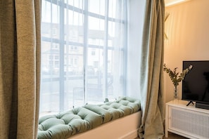 Relax in a comfortable seating area with a flat-screen TV and enjoy the view from the large window.