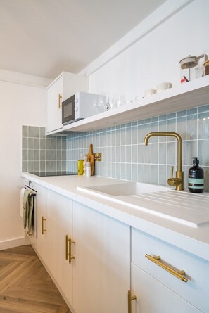 Enjoy cooking in this well-equipped kitchen with a sink, microwave, and ample storage.