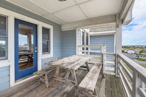 A wooden deck with picnic tables and a blue door. - Captain Jack's Landing: Oceanside w/ Pool, Hot Tub (Nags Head)