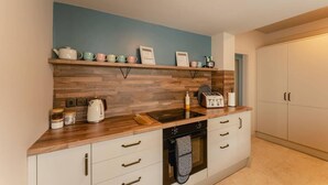 A modern kitchen with wooden countertops, a built-in oven, and a coffee machine. - Swan House 3-bed Town House York - up to 5 Guests (York)