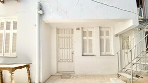 Un edificio blanco con suelo de baldosas, una mesa de madera y una escalera.