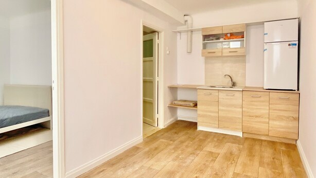 Una cocina moderna con armarios de madera, un refrigerador y una encimera.