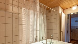 Une salle de bain moderne avec un grand miroir, un double vasque et un rideau de douche.