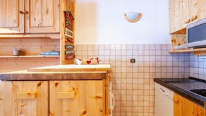 Une cuisine avec des meubles en bois, un dosseret carrelé et un lave-vaisselle.
