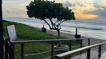 Na praia, areia branca, espreguiçadeiras, guarda-sóis