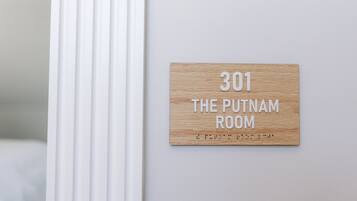 A wooden sign with the number 301 and the text 'The Putnam Room' on a white wall.