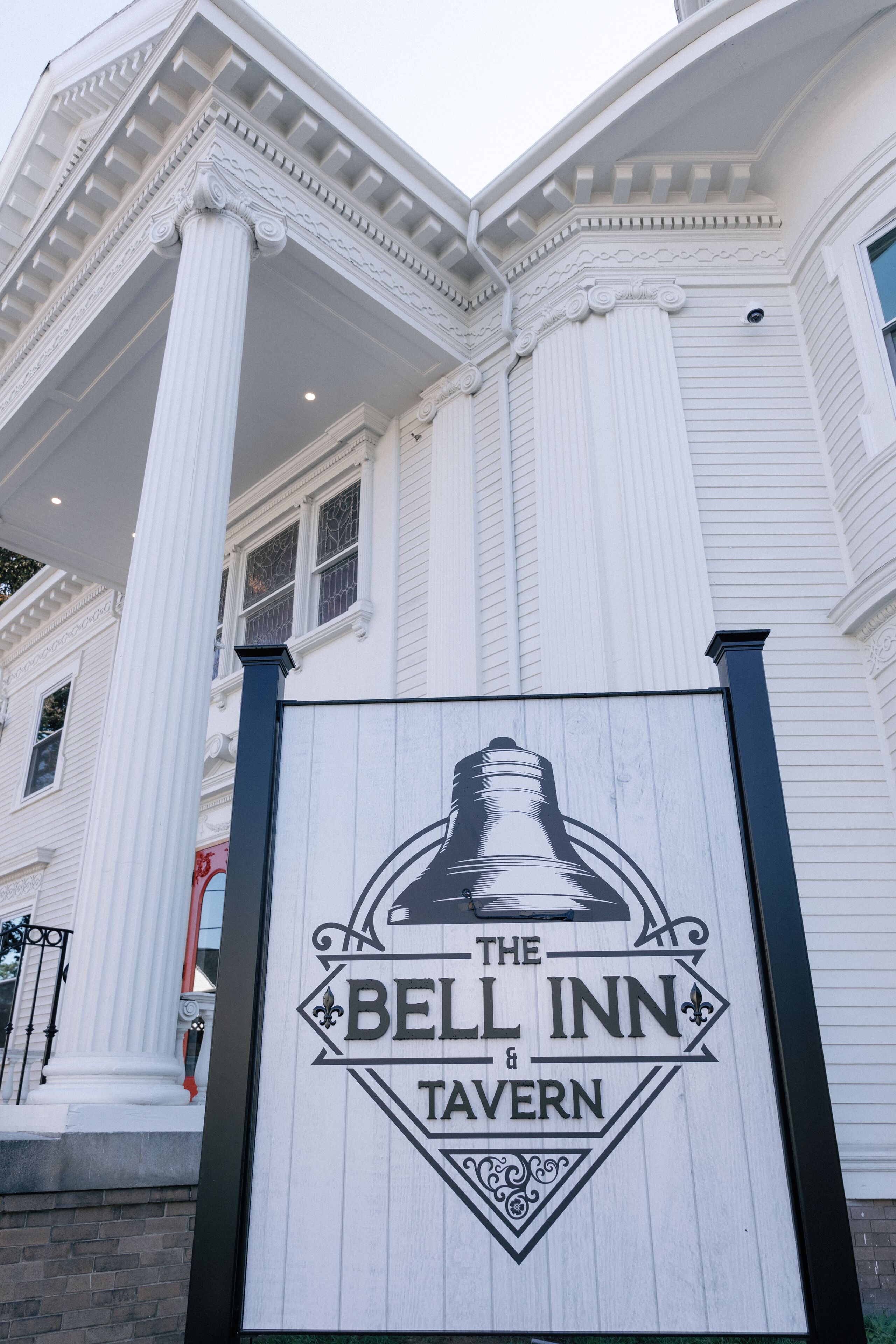 A sign for The Bell Inn & Tavern with a bell graphic.