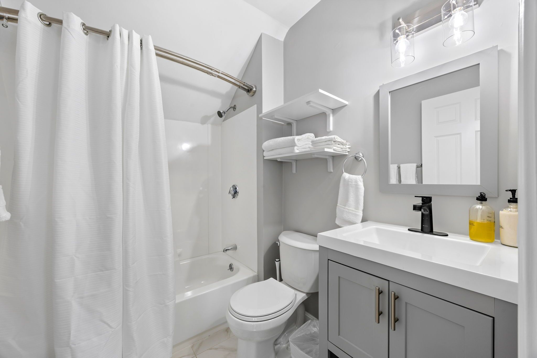 A modern bathroom with a bathtub, toilet, and sink.