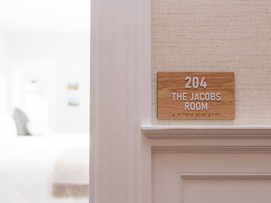 Placa na parede indicando o quarto número 204, identificada como 'The Jacobs Room'.