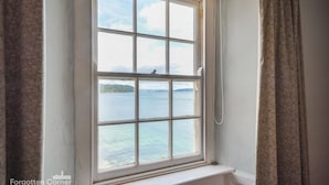 Una ventana con vistas a una masa de agua y tierra a lo lejos.