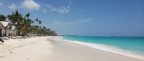 On the beach, white sand, sun-loungers, beach umbrellas