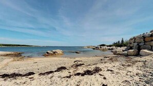 Une plage avec une eau claire, des rochers et un amas de pierres.