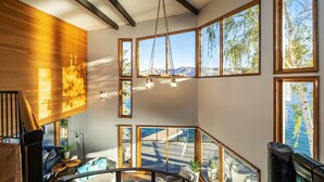 A spacious interior with large windows, a wooden ceiling, and a view of the outdoors. - Premier home, Waterfront, Views, Hot Tub, Dogs OK (Lake Chelan)