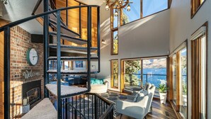 A multi-level living space with a spiral staircase, a fireplace, and a view of the sea. - Premier home, Waterfront, Views, Hot Tub, Dogs OK (Lake Chelan)