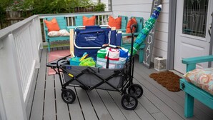 Ein Babywagen auf einem Holzboden mit Babyaufsatz, einer Wickeltasche und einem Schild mit der Aufschrift 'SEDA'.