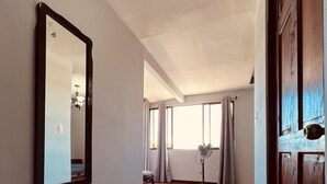 A spacious hallway with wooden flooring, a large mirror, and a door leading to another room. - CASA DEL ARBOL ESCAZU (San Antonio)