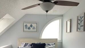 A bedroom with a bed, a ceiling fan, a skylight, and framed botanical prints on the walls. - Sugar Ski Premium Loft - Unit 11-703 (Sugar Mountain)