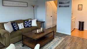 A living room with a brown sofa, a coffee table, and a ceiling fan. - Sugar Ski Premium Loft - Unit 11-703 (Sugar Mountain)