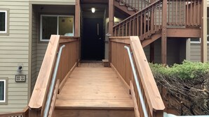 A wooden staircase leading to a second-floor entrance of a building with a mailbox and a number 11 sign above the door. - Sugar Ski Premium Loft - Unit 11-703 (Sugar Mountain)