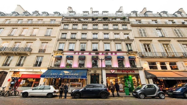 Une rangée de bâtiments historiques abritant des commerces, notamment un restaurant et un bar à sushis.